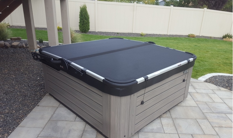 a hot tub with cover on a patio